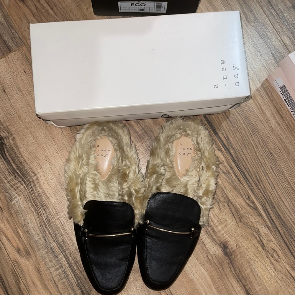 Furry mule flats in black and faux is light brown.